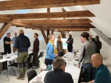 Deltagere i samtale ved bordene til et netværksmøde