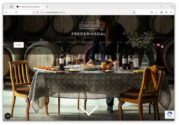Forsiden af frederiksdal.com med dækket bord i vinkælderen og sprogvalg i menuen